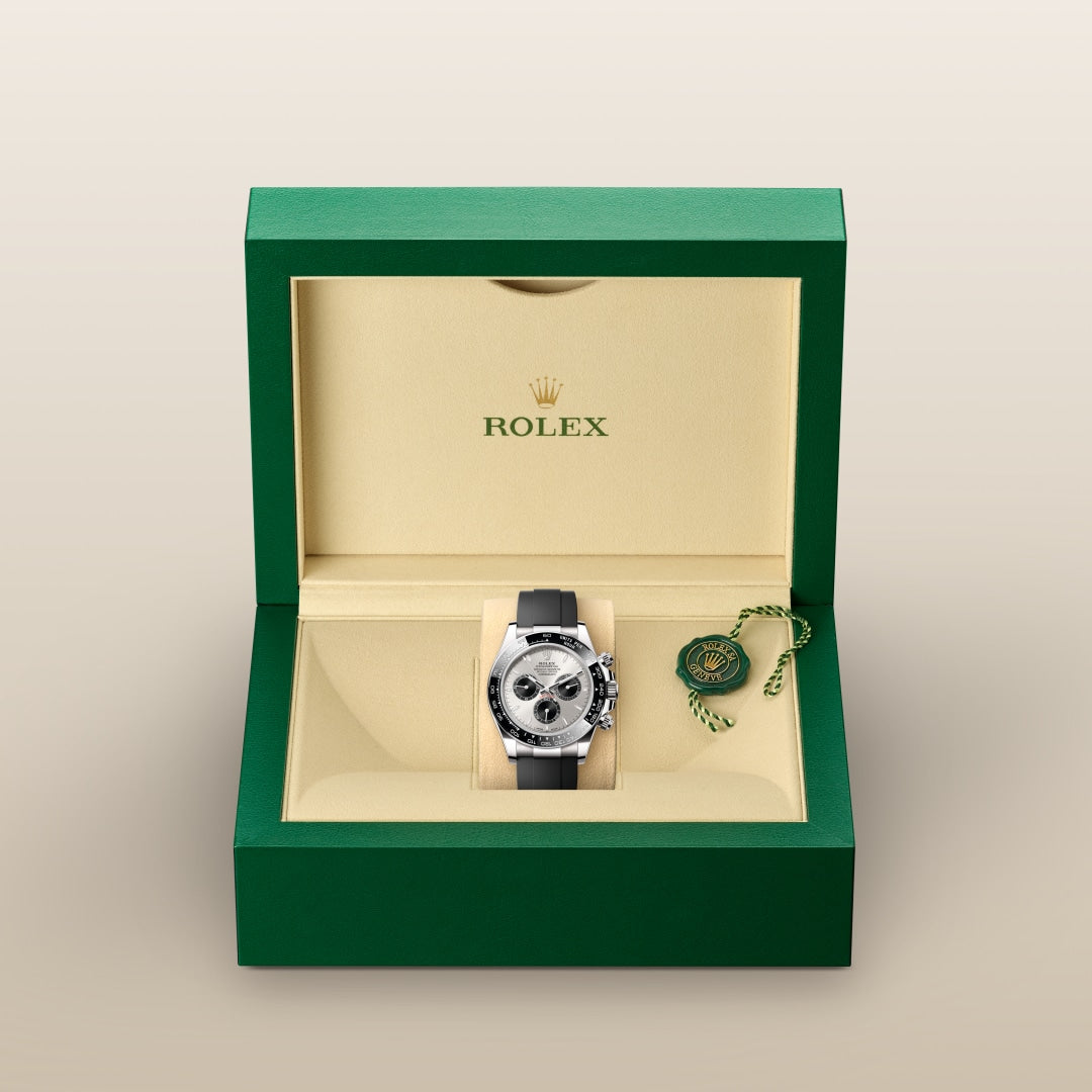 A Rolex watch with a black strap in a green and cream box, with the Rolex logo inside the lid.