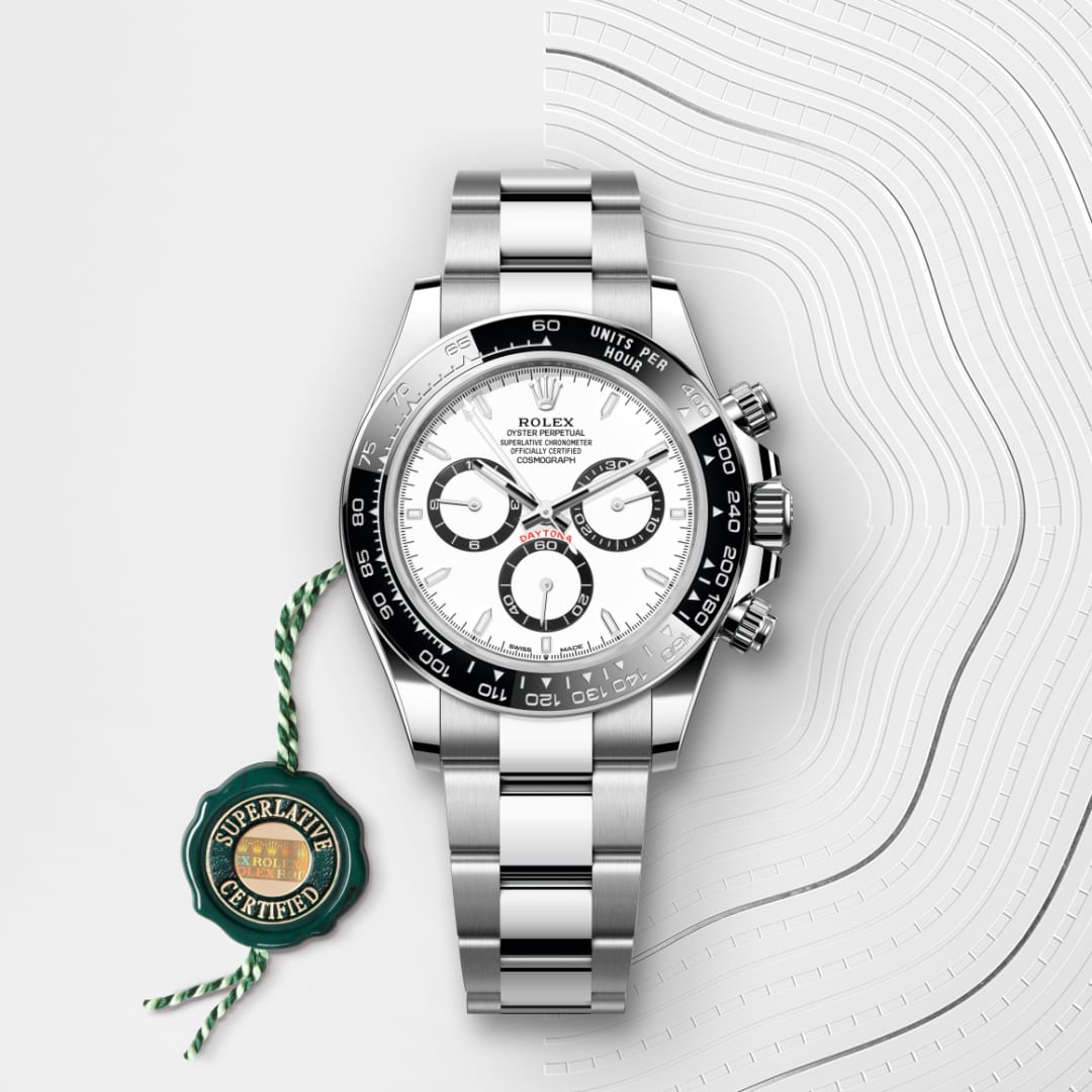 A Rolex Daytona stainless steel watch with a white dial and black bezel on a patterned white background.