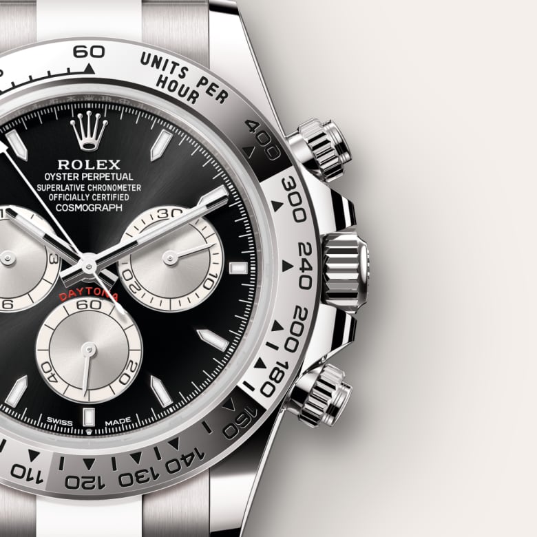 Close-up of a Rolex Cosmograph Daytona watch with a black dial and silver subdials on a metal bracelet.