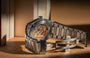 Luxury watch with a metallic band on a wooden surface