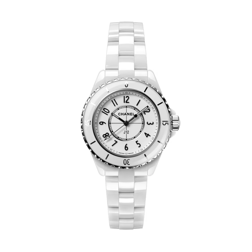 The Chanel J12 wristwatch features a white ceramic case, round face, black numerals, and silver bezel, renowned for high precision, shown against a plain white background.