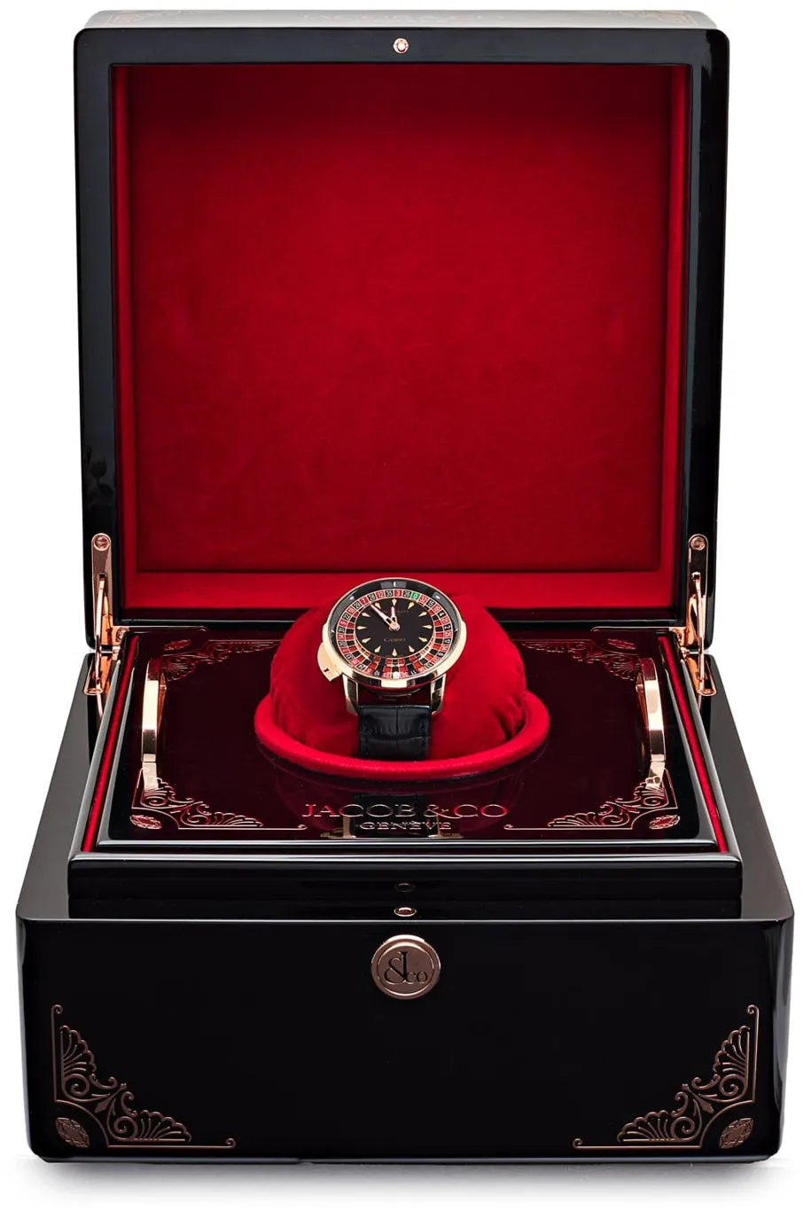 Black watch winder box with red velvet interior displaying tourbillon watch with roulette wheel dial on red cushion.
