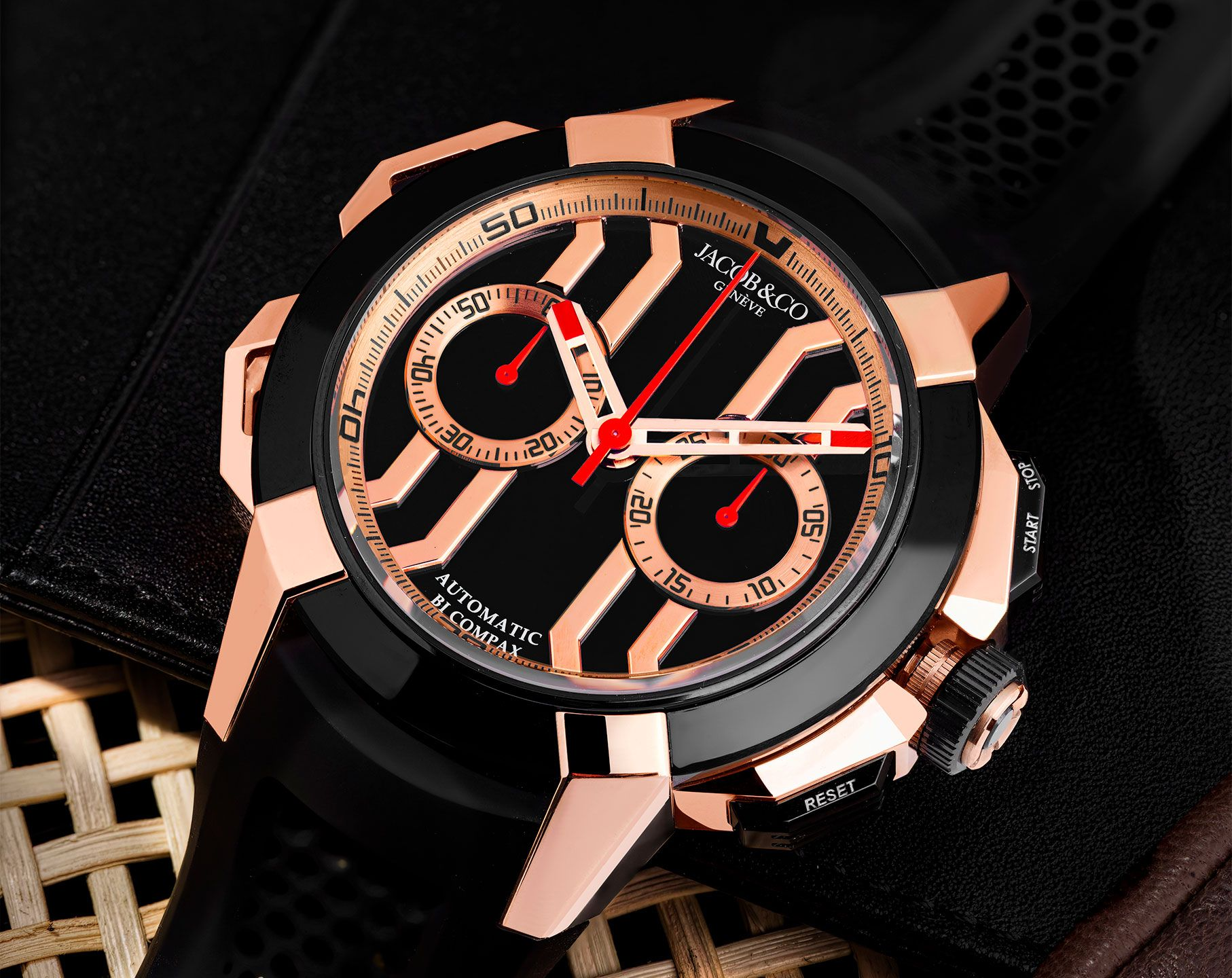 Black and rose gold chronograph watch with geometric case design, black dial, red and white hands, and multiple subdials.
