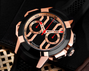 Black and rose gold chronograph watch with geometric case design, black dial, red and white hands, and multiple subdials.