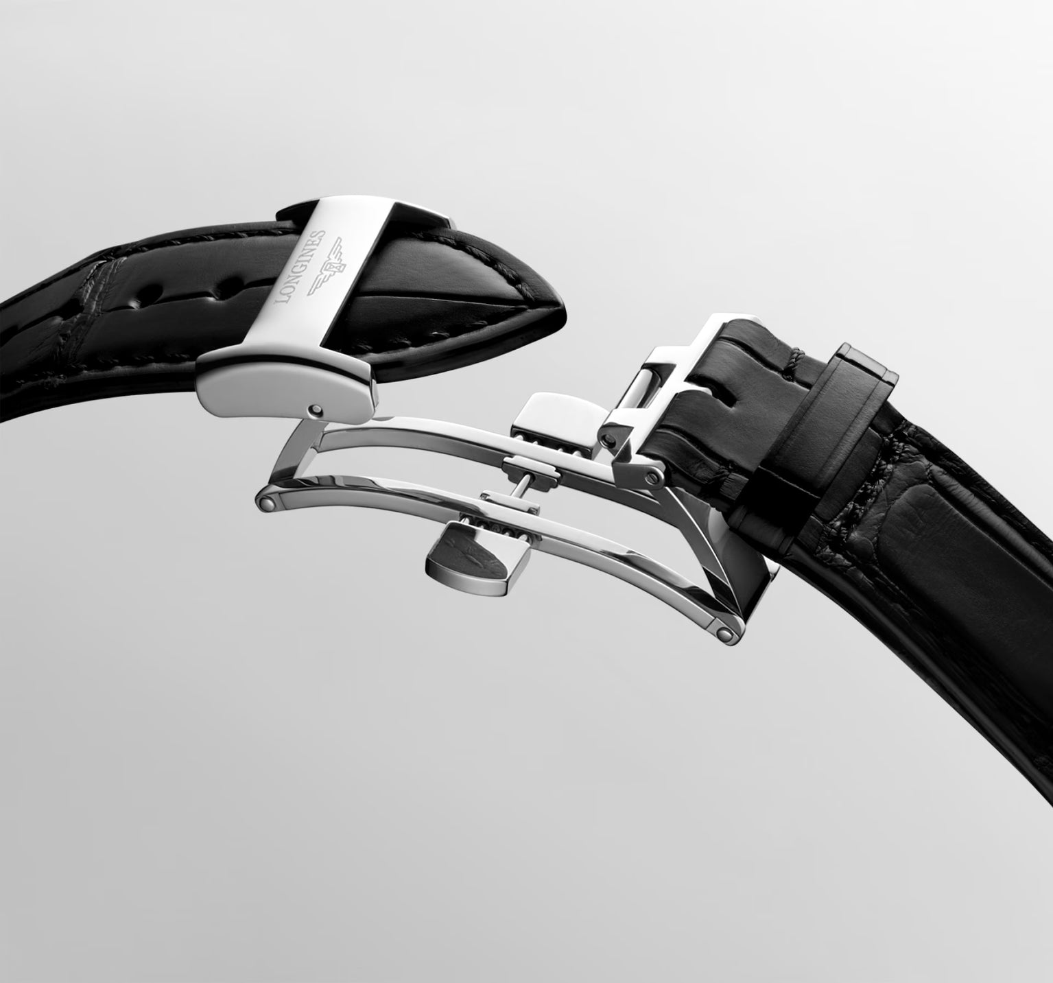 Close-up of the Longines Master Collection Year of the Horse’s black leather strap with a stainless steel deployment clasp, open against a plain light background—highlighting refined watchmaking craftsmanship.