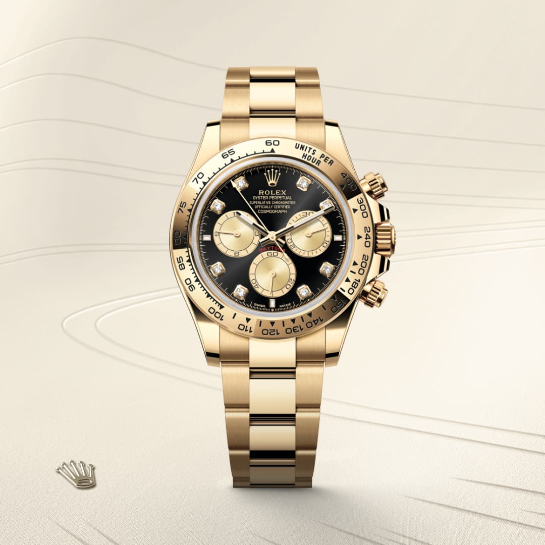 A gold Rolex Daytona watch with a black and gold dial displayed on a light textured background.