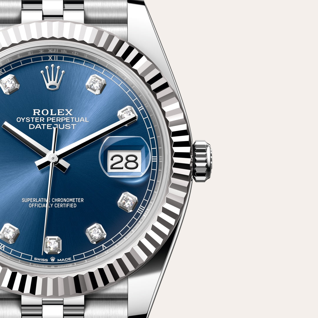 Close-up of a Rolex Datejust watch with a blue dial, diamond hour markers, and date display at 3 o’clock.
