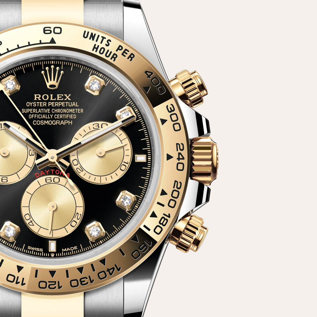 Close-up of a Rolex Cosmograph Daytona watch with a black and gold dial, diamond hour markers, and gold bezel.