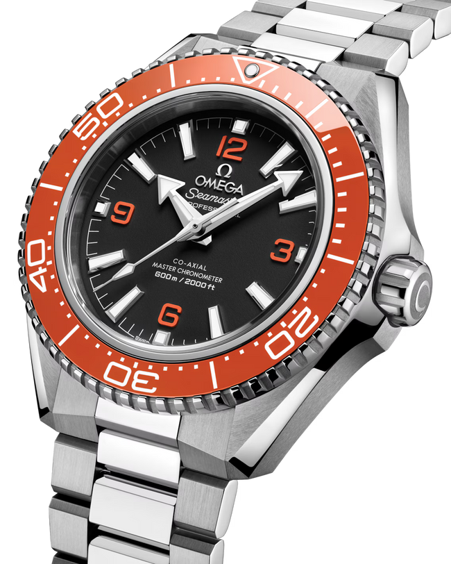 A close-up of the OMEGA Seamaster Planet Ocean 600M, a silver dive watch featuring a stainless steel band, black dial, and bold orange bezel with minute markers, displaying the time and its 600m/2000ft depth rating.