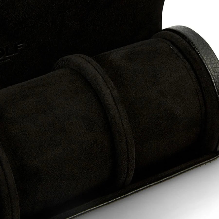 Black suede watch roll with three cylindrical compartments and carrying strap.