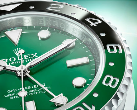 Close-up of a green Rolex GMT-Master II watch face with silver hour markers and hands.