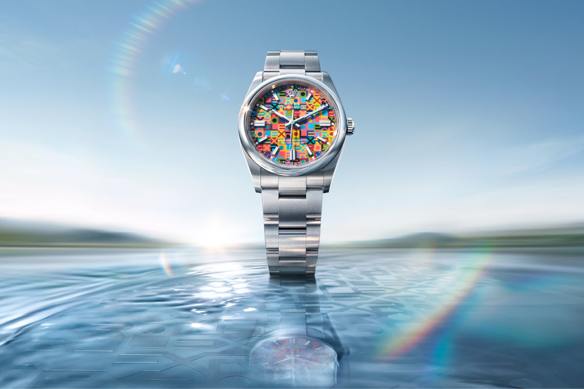 Silver watch with a colorful face on a reflective water surface with a blue sky background