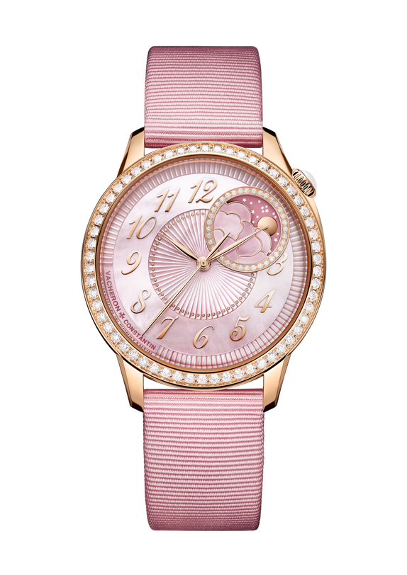 Rose gold watch with pink dial, diamond bezel, moon phase complication, and pink textile strap.