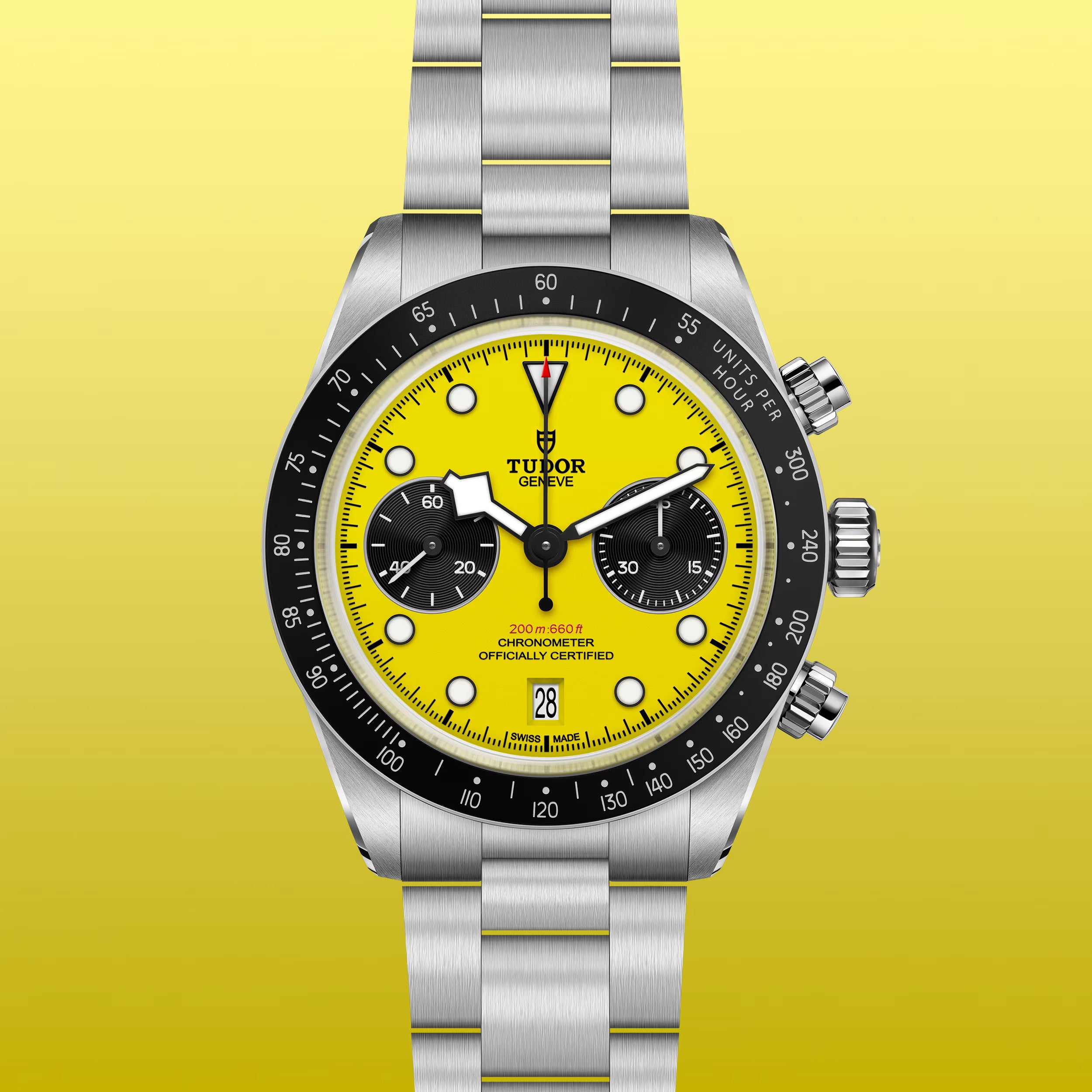 Tudor chronograph watch with yellow dial, black bezel, two black subdials, and steel bracelet on yellow background.